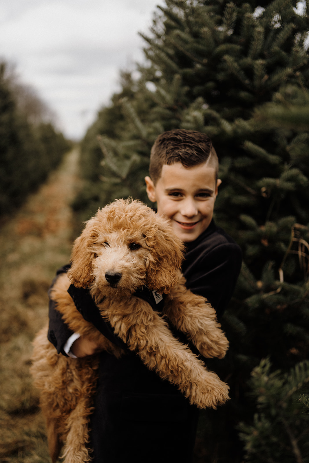 A child holding his dog outside.