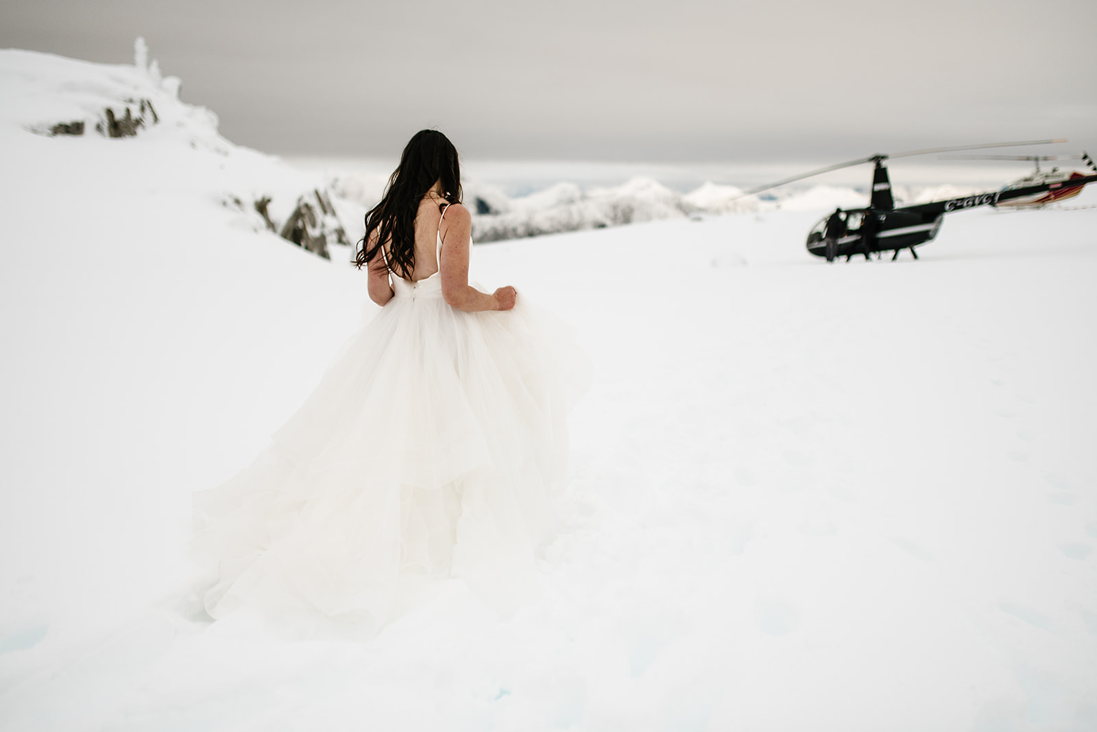 bride walking to snowy helicopter
