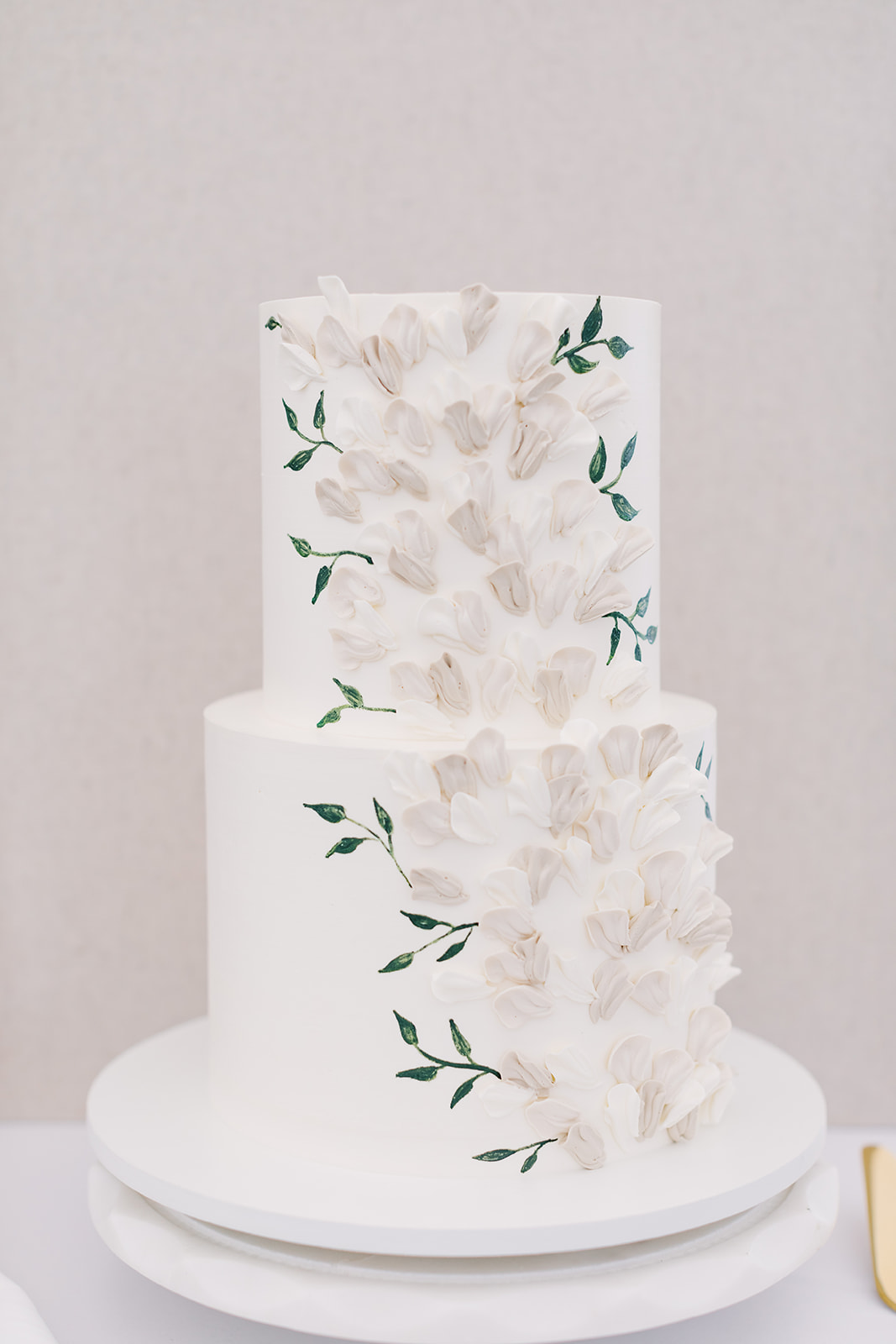 custom floral cake with neutral and greenery accents