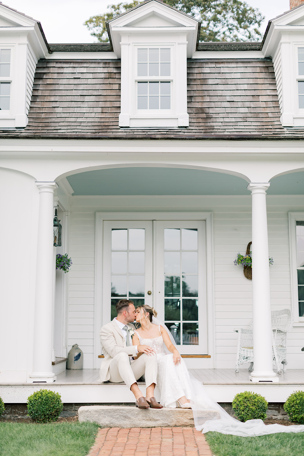 couple's portrait in the front of house at smith farm gardens wedding sitting on steps