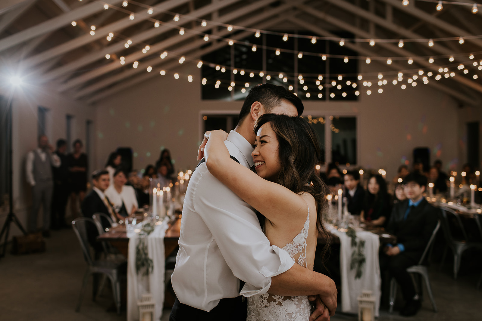 a bride rests her head on the grooms shoulder during the first dance 