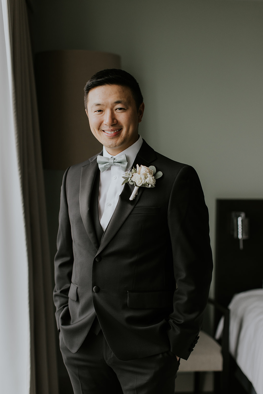 a groom looks and smiles and the camera in Sidney BC