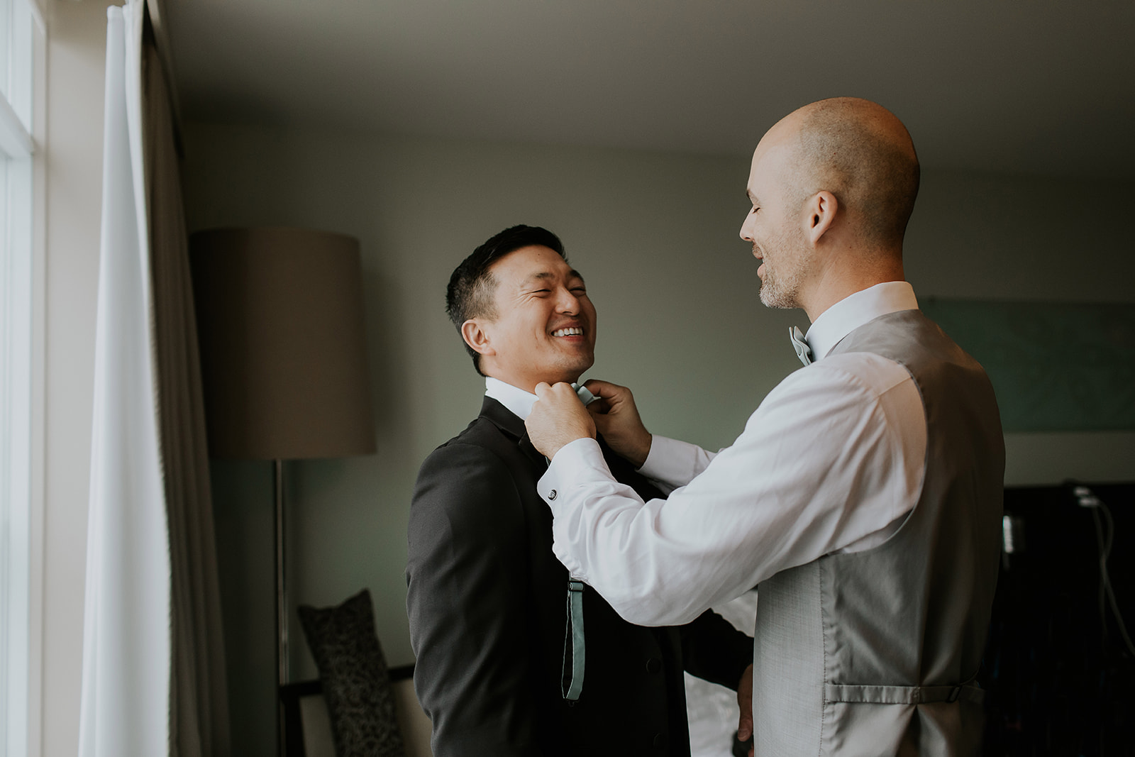 the best man helps the groom tie his tie at the Sidney Pier Hotel