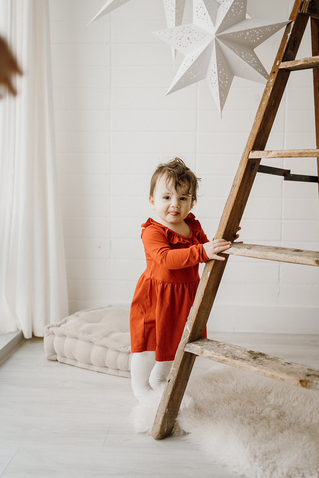 A toddler standing by the ladder.