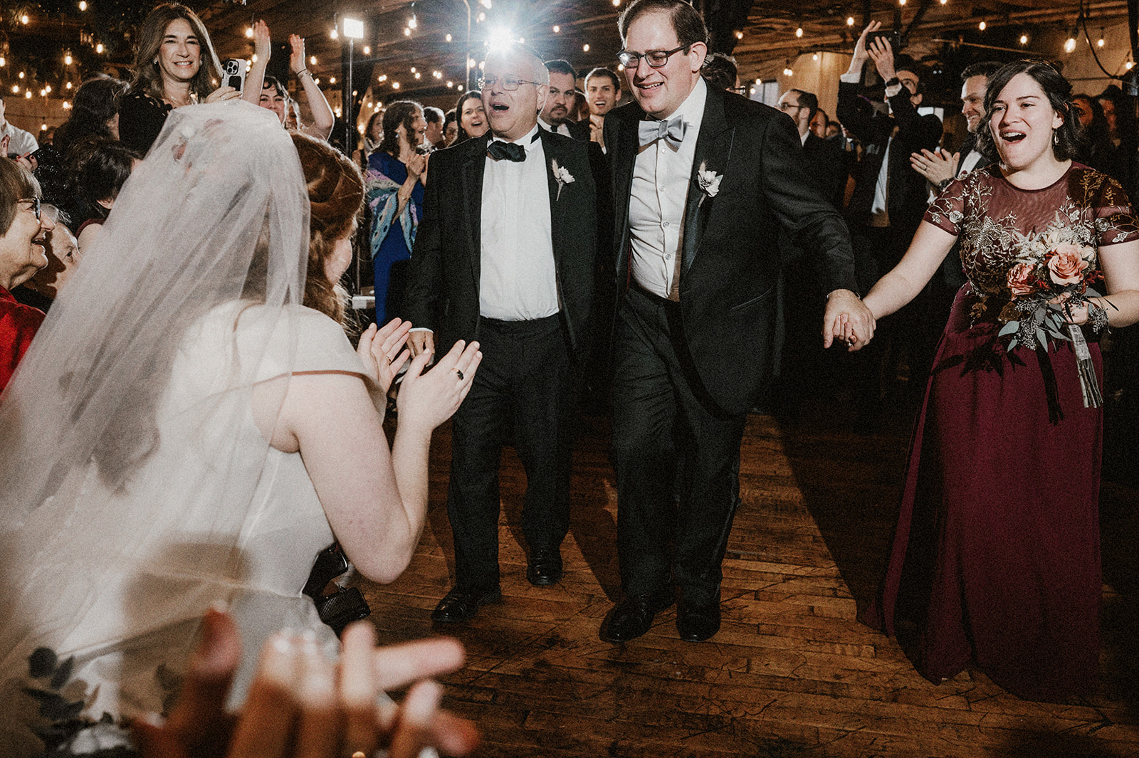 groom approaching bride in joyful moment of bedeken during modern orthodox jewish wedding at art factory
