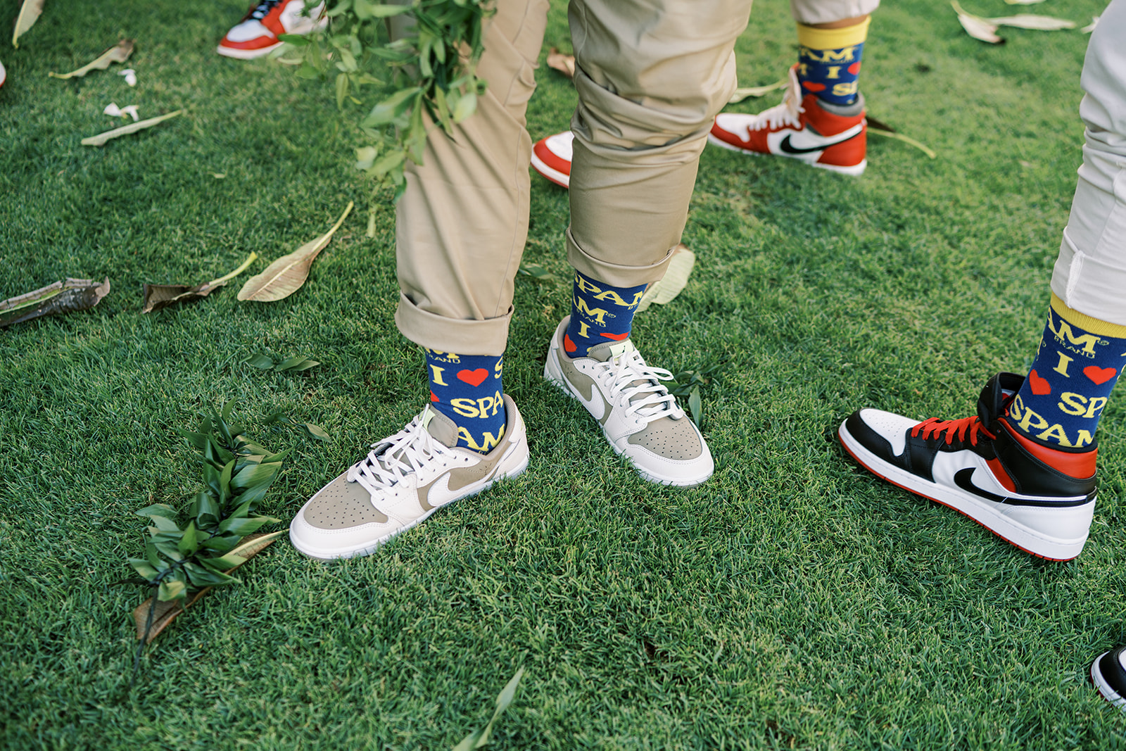 Two people wearing sneakers with "superman" themed socks standing on grass at Hawaiian Wedding in Kauai
