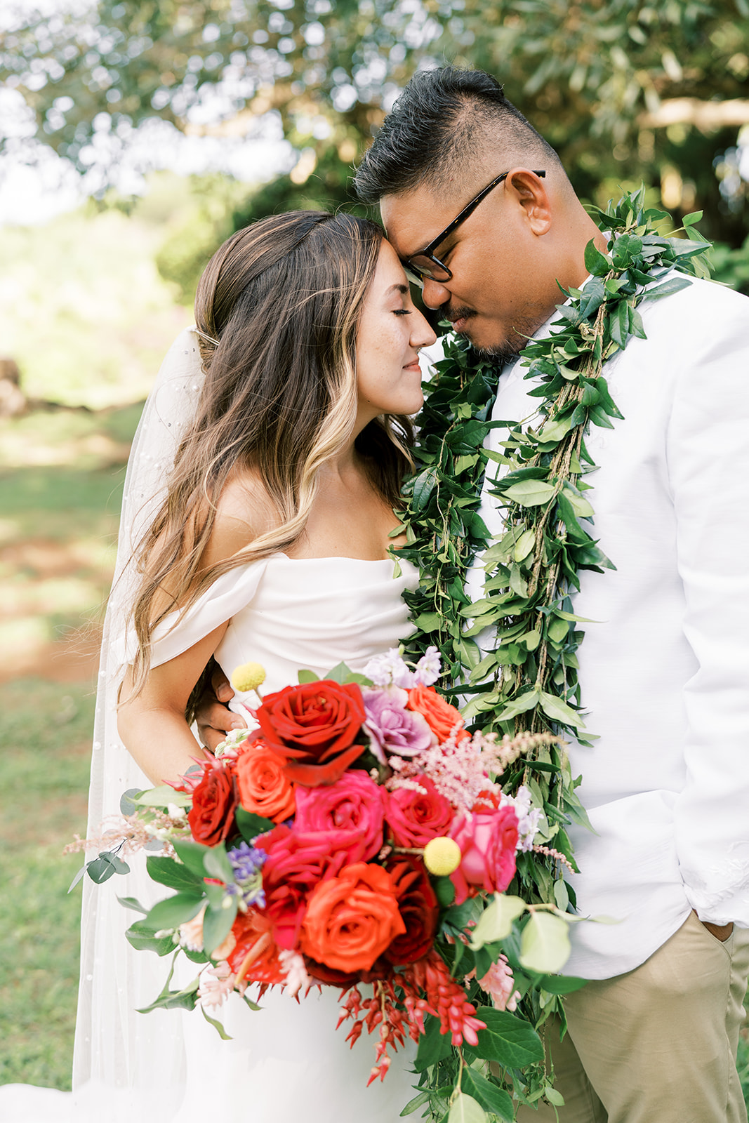 Bride and groom sharing a moment at their Hawaiian wedding, surrounded by greenery in Kauai
