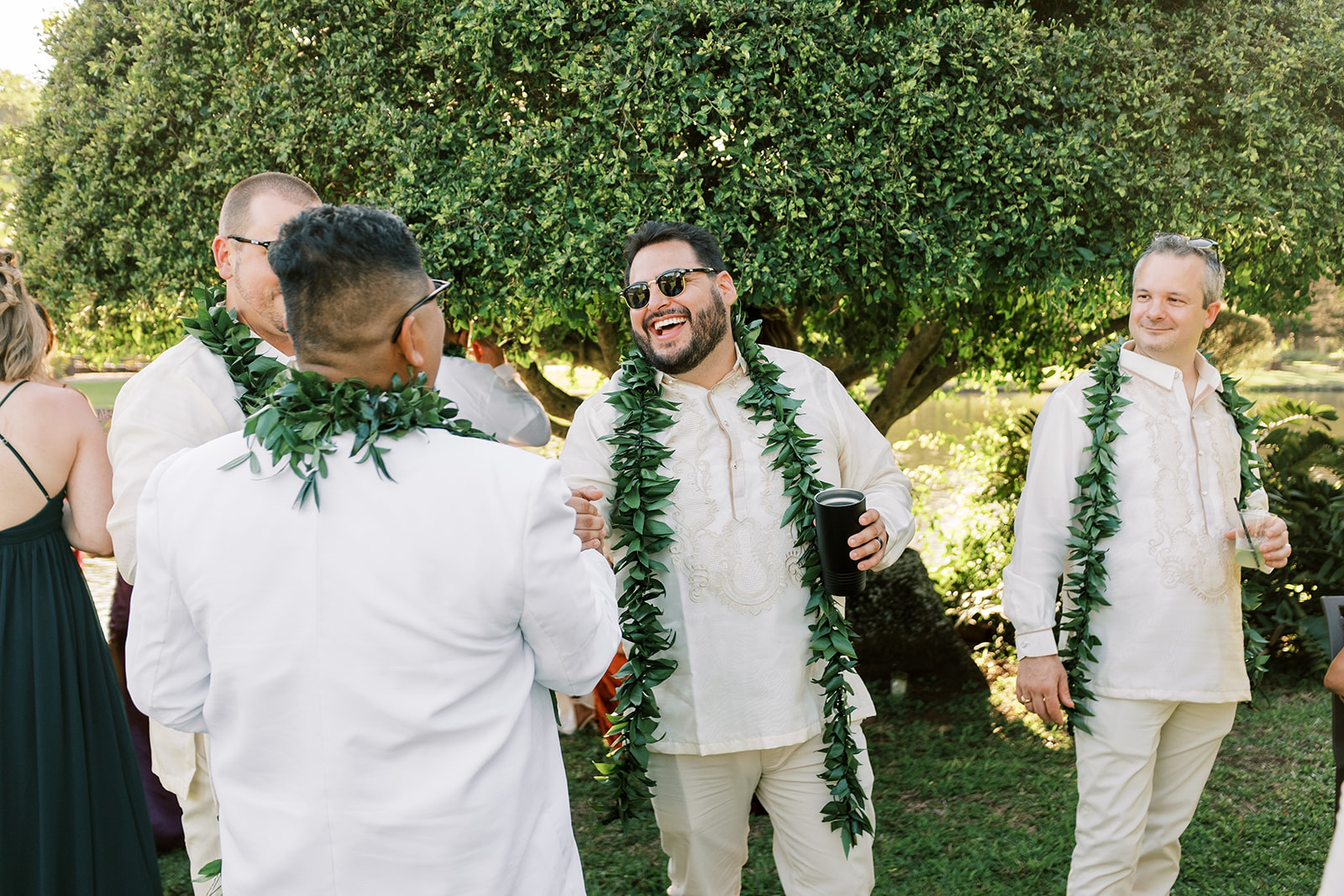 A joyful gathering of the groomsmen laughing and wearing a lei Hawaiian Wedding in Kauai