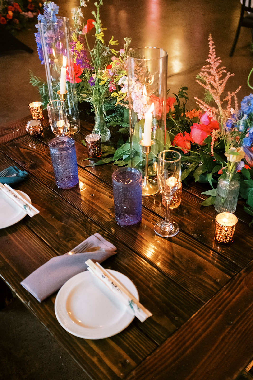 Elegant table setting with colorful flower arrangements and candle centerpieces Smiths Tropical Paradise Luau