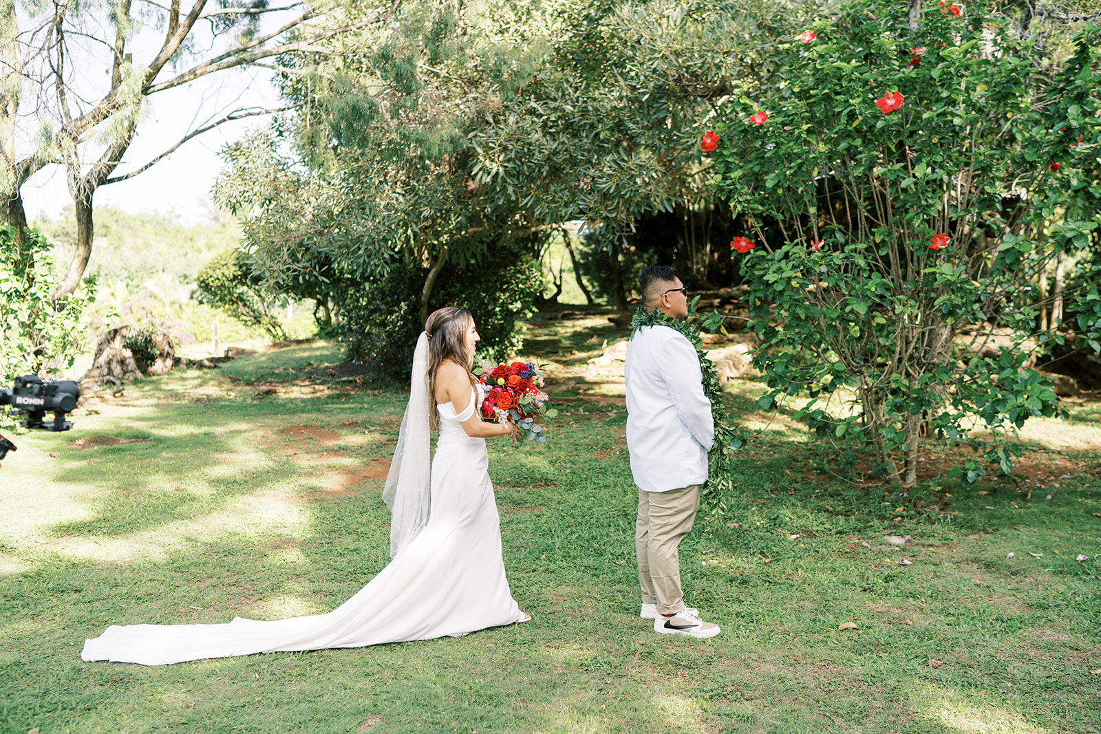 Bride and groom participating in a "first look" moment in a garden setting captured by Megan Moura Wedding Photographer