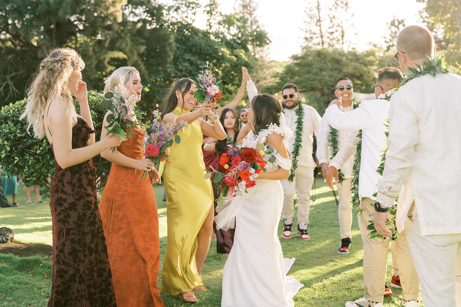 A joyful outdoor wedding scene with well-dressed guests congratulating the bride and groom taken by Megan Moura Wedding