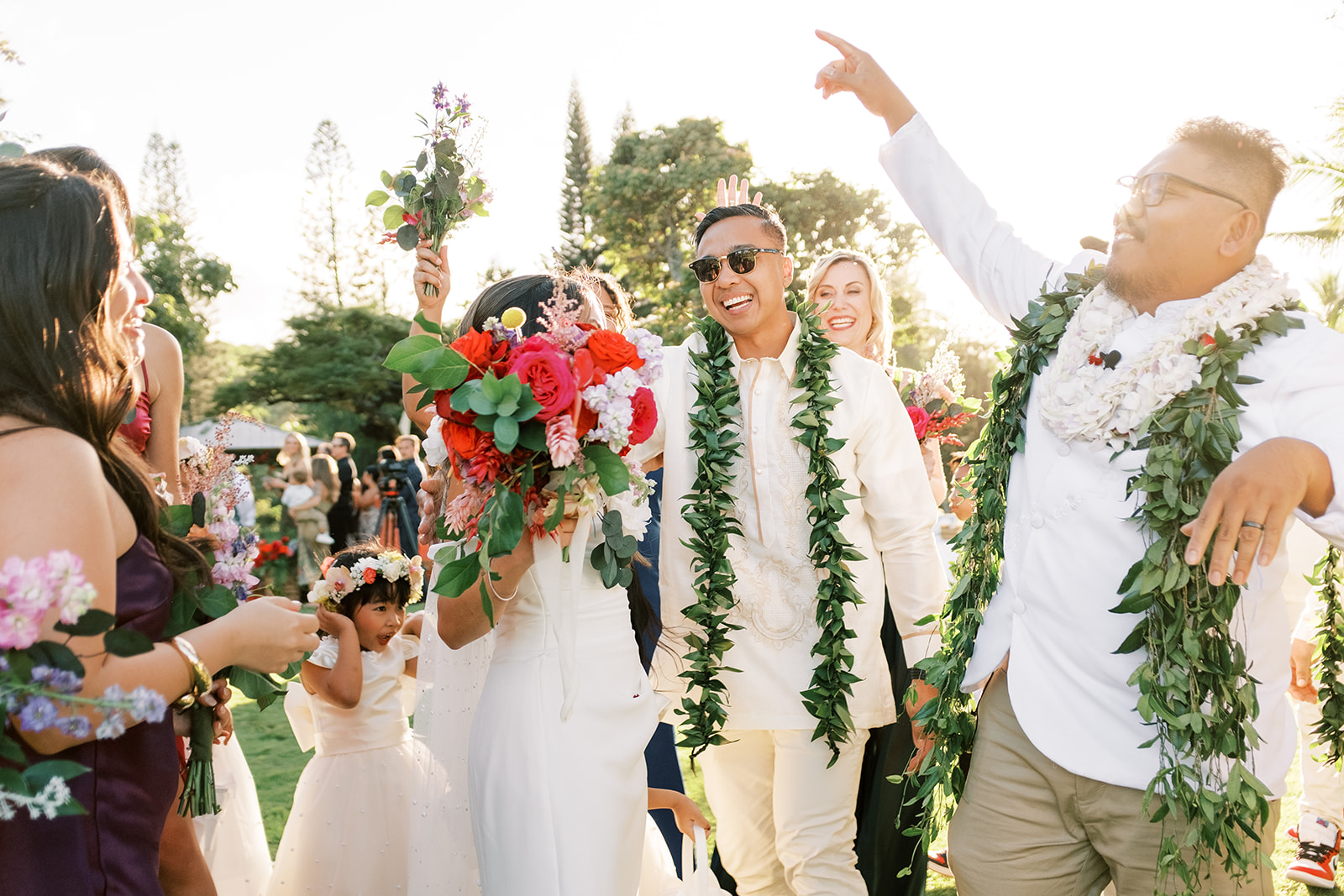 A joyous wedding procession with the newlyweds and guests celebrating at Smiths Tropical Paradise and Luau