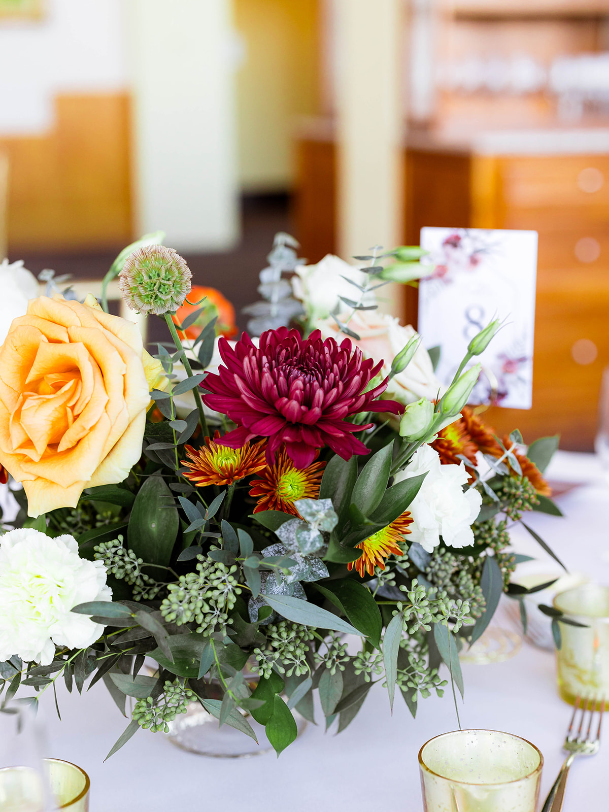 orange and green wedding floral centerpiece on table