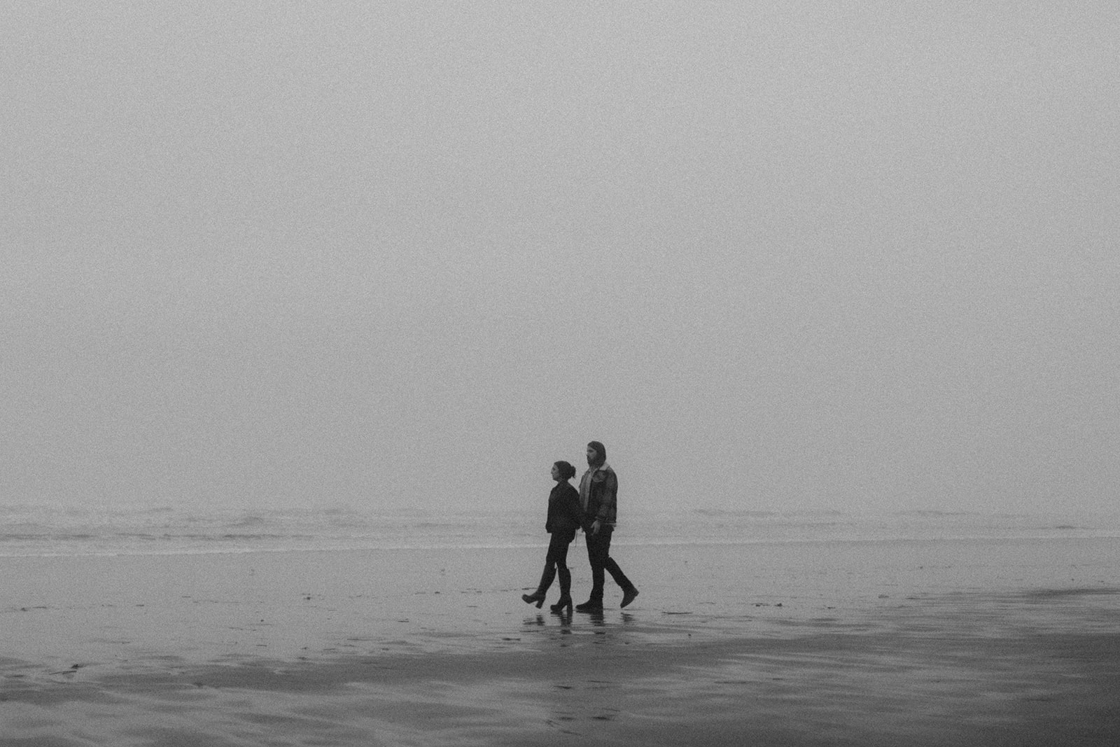 Black and white photo of couple during their engagement session in Gearhart, Oregon on beach