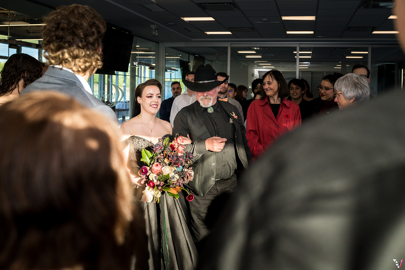 The bride's arrival is on the arm of her father, who came from Calgary, walking down the aisle. 