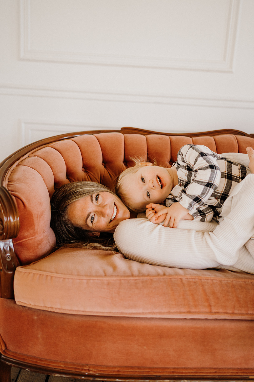 A mother and child lying on the couch together.