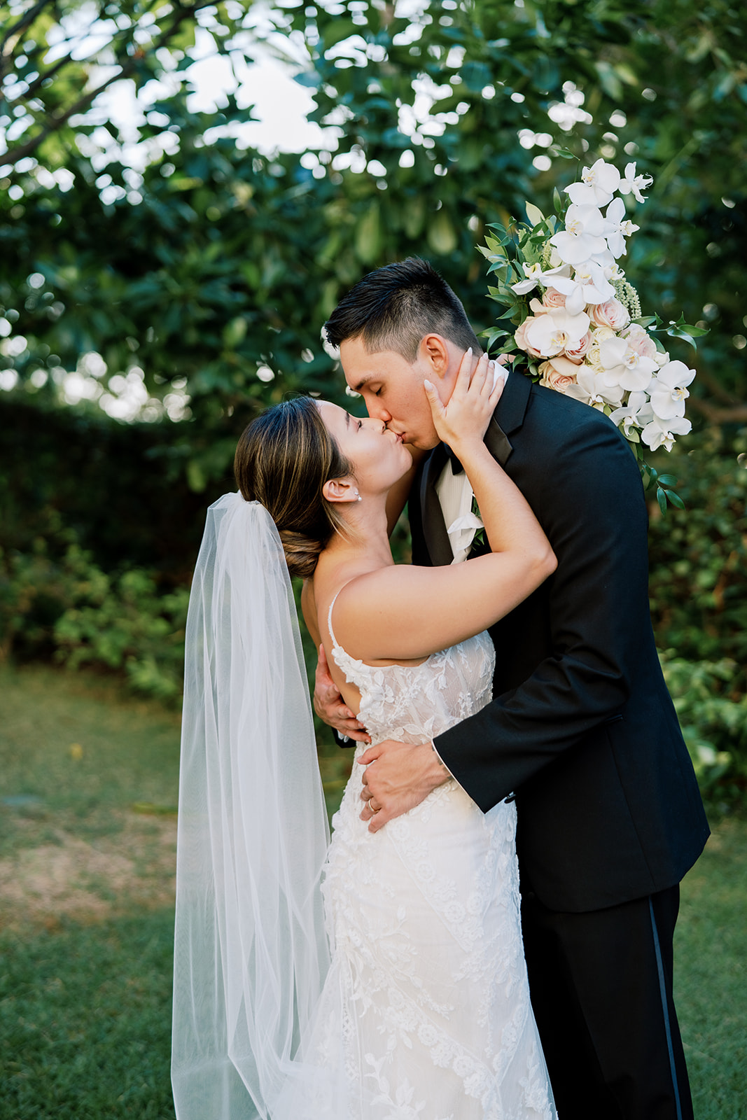 A close up photo of a bride and groom kissing in the garden at The Four Seasons Resort captured by Megan Moura