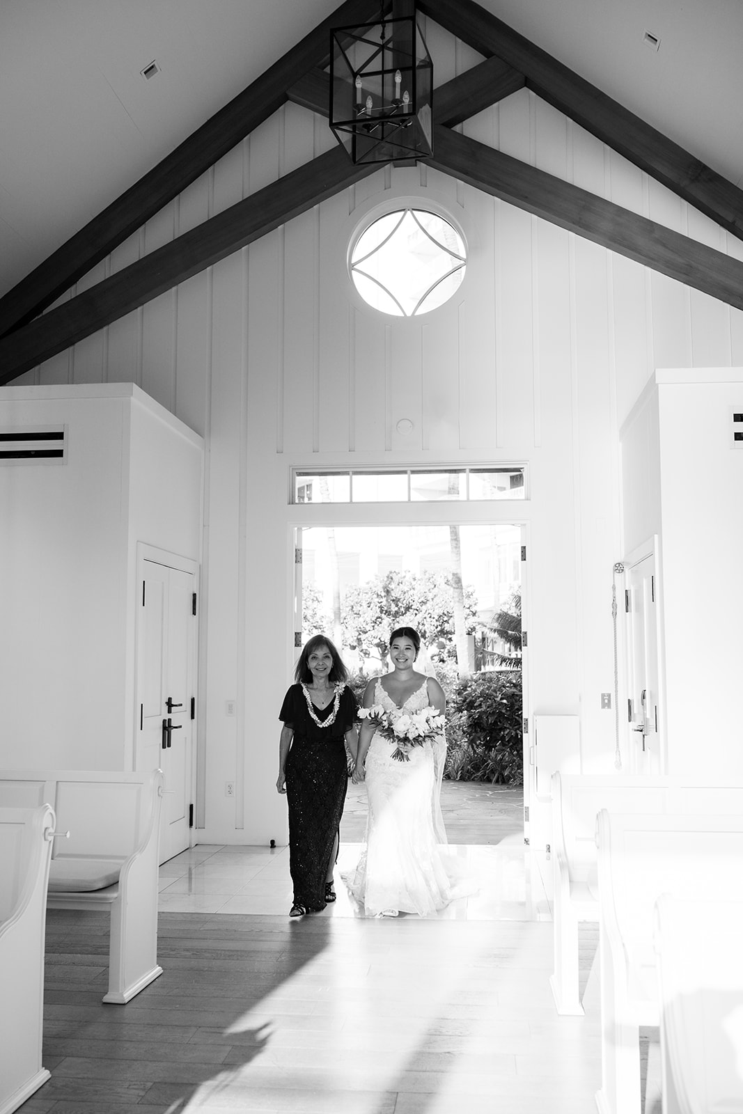 A bride walks down the aisle with her mother in The Four Seasons Hawaii
