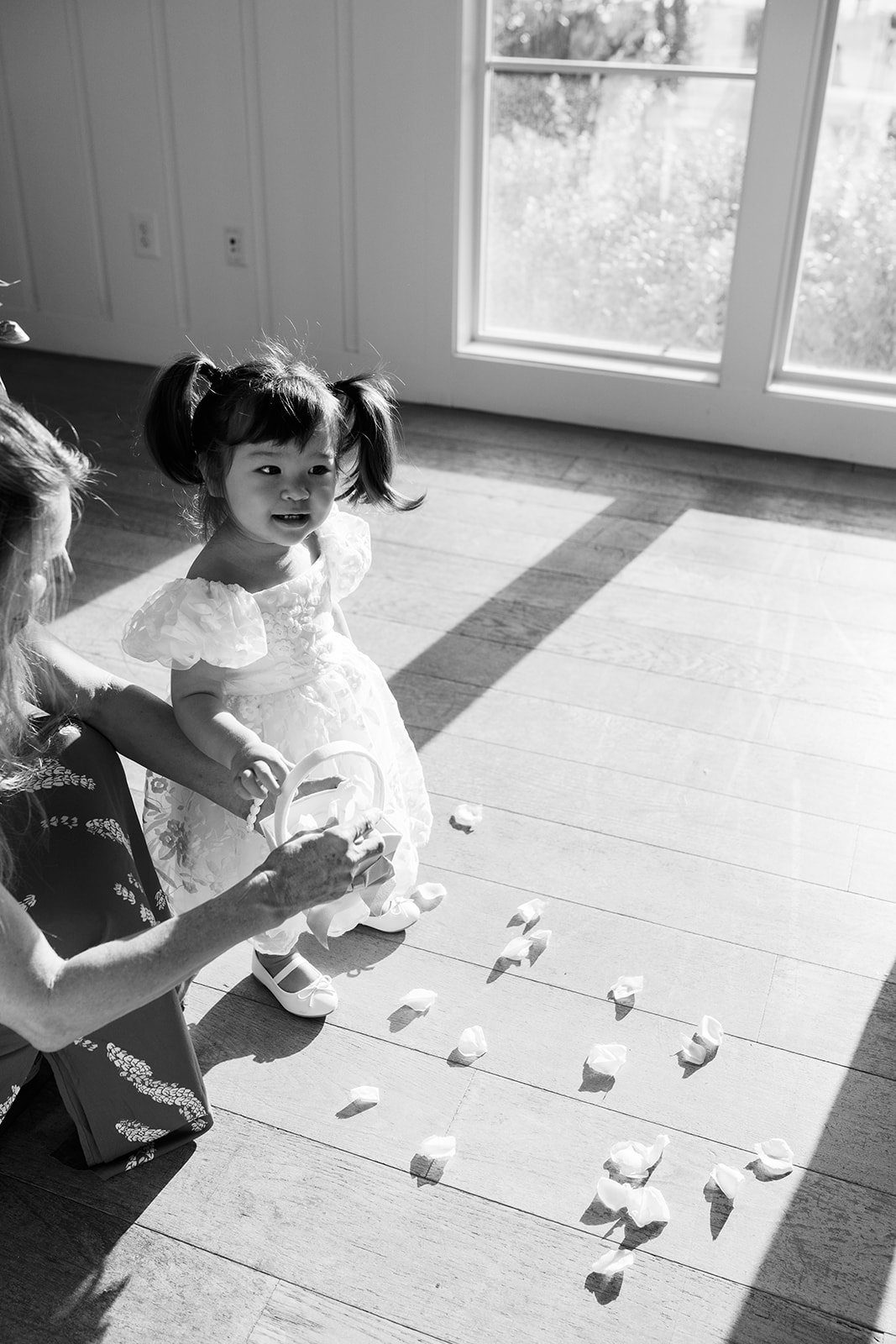 A woman and a child flower girl throwing flower petals on the floor.
