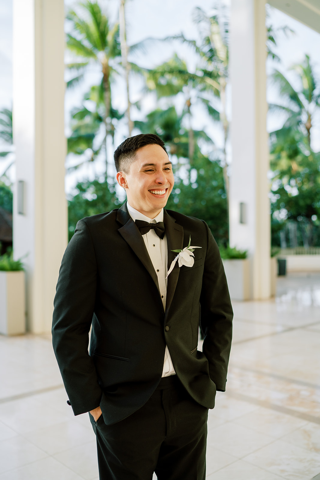 A groom in a tuxedo smiles taken by Megan Moura Wedding Photographer