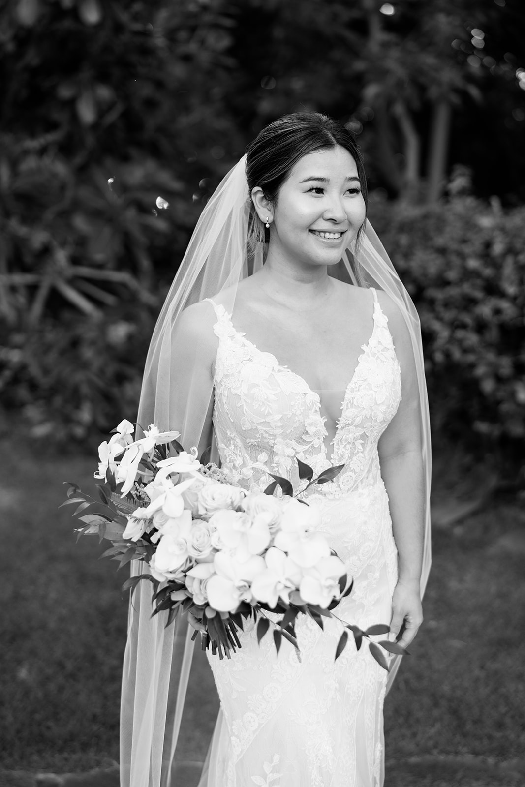 Black and white photo of a bride holding a bouquet taken by Megan Moura Hawaii Wedding Photographer 