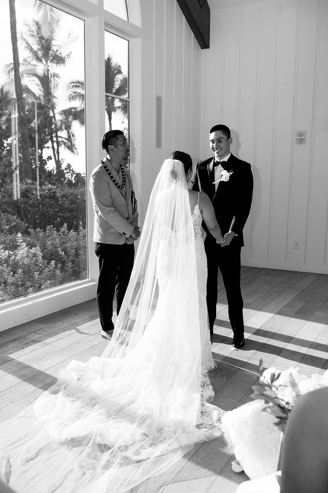 A black and white poto taken by Megan Moura of the bride and groom exchanging vows in the chapel at the Four Seasons