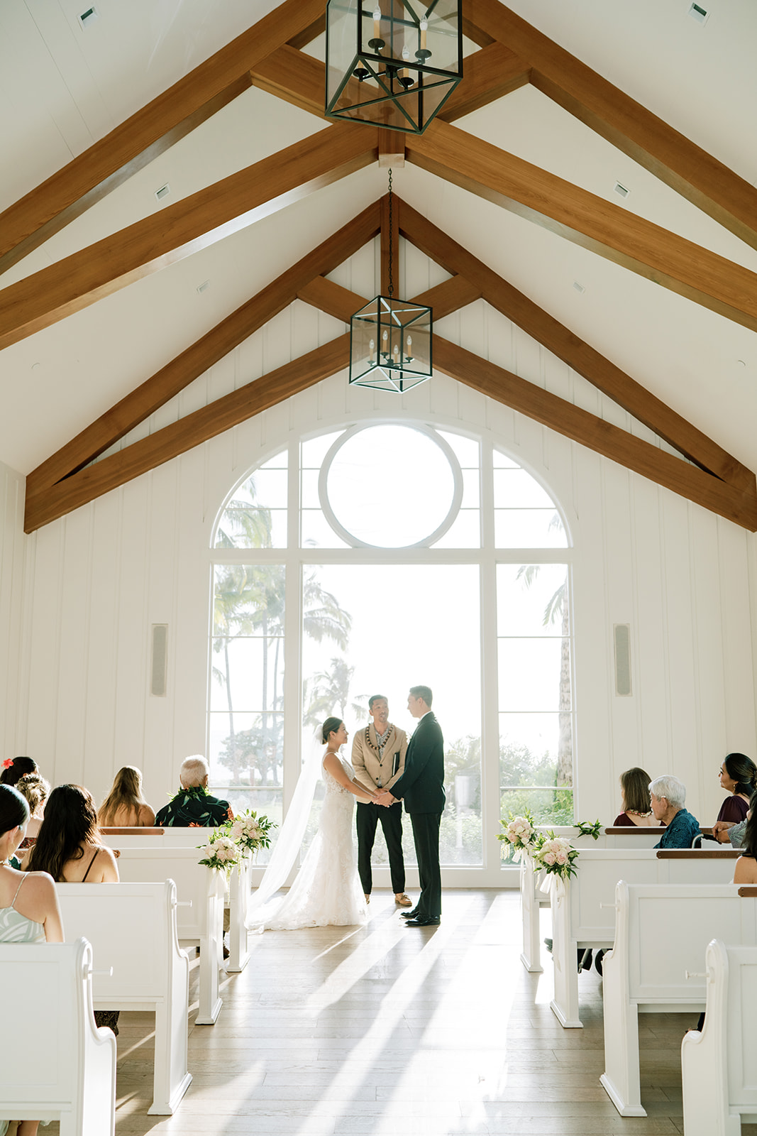A wedding ceremony in a church with wooden pews captured by Megan Moura Wedding Photographer.