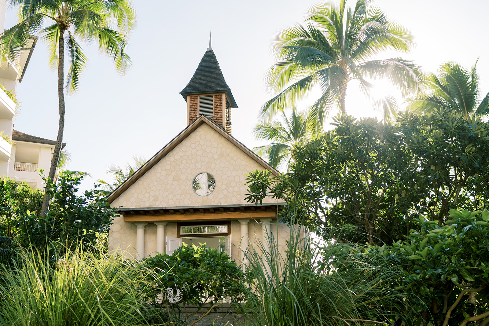 A small chapel in The Four seasons surrounded by palm trees.