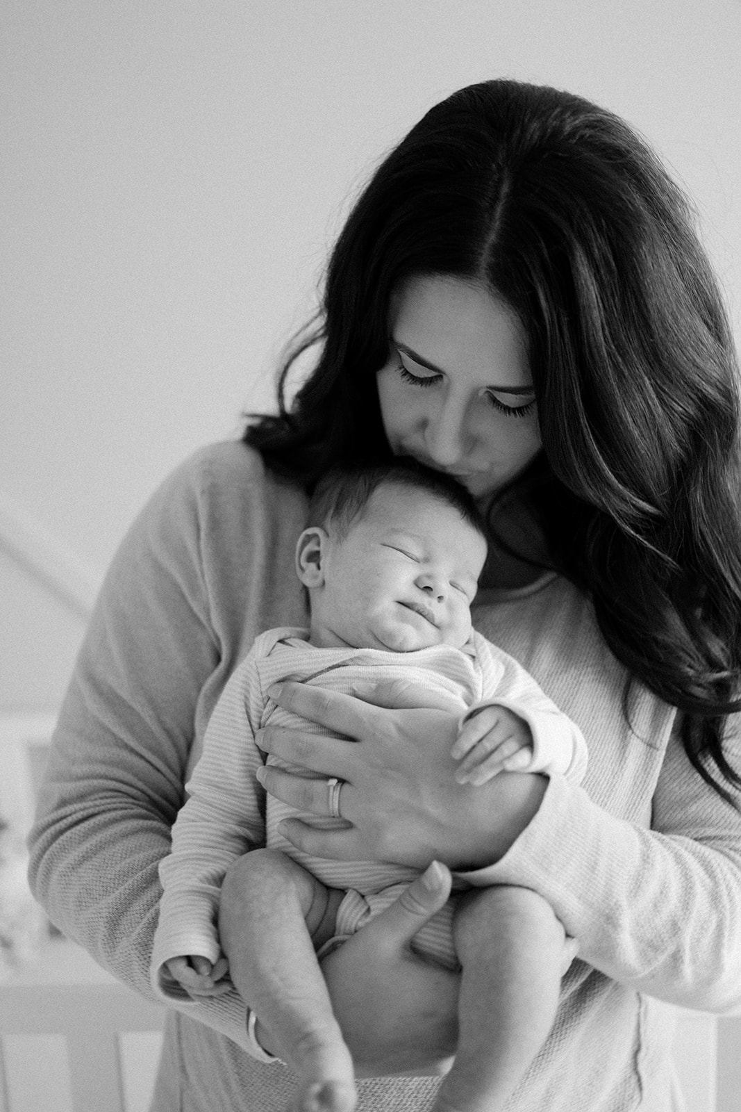 Newborn being held in moms arms.