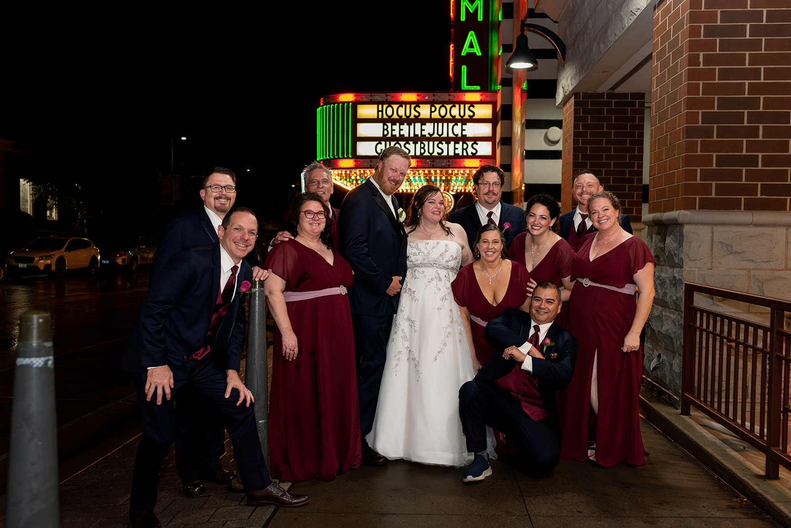 theater marquee in background of bridal party photo