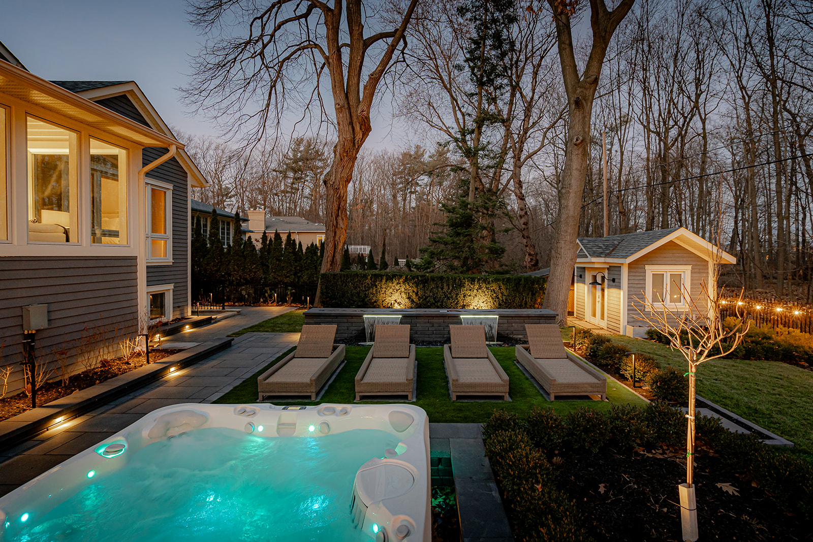 A jacuzzi with lounge chairs in the back yard.