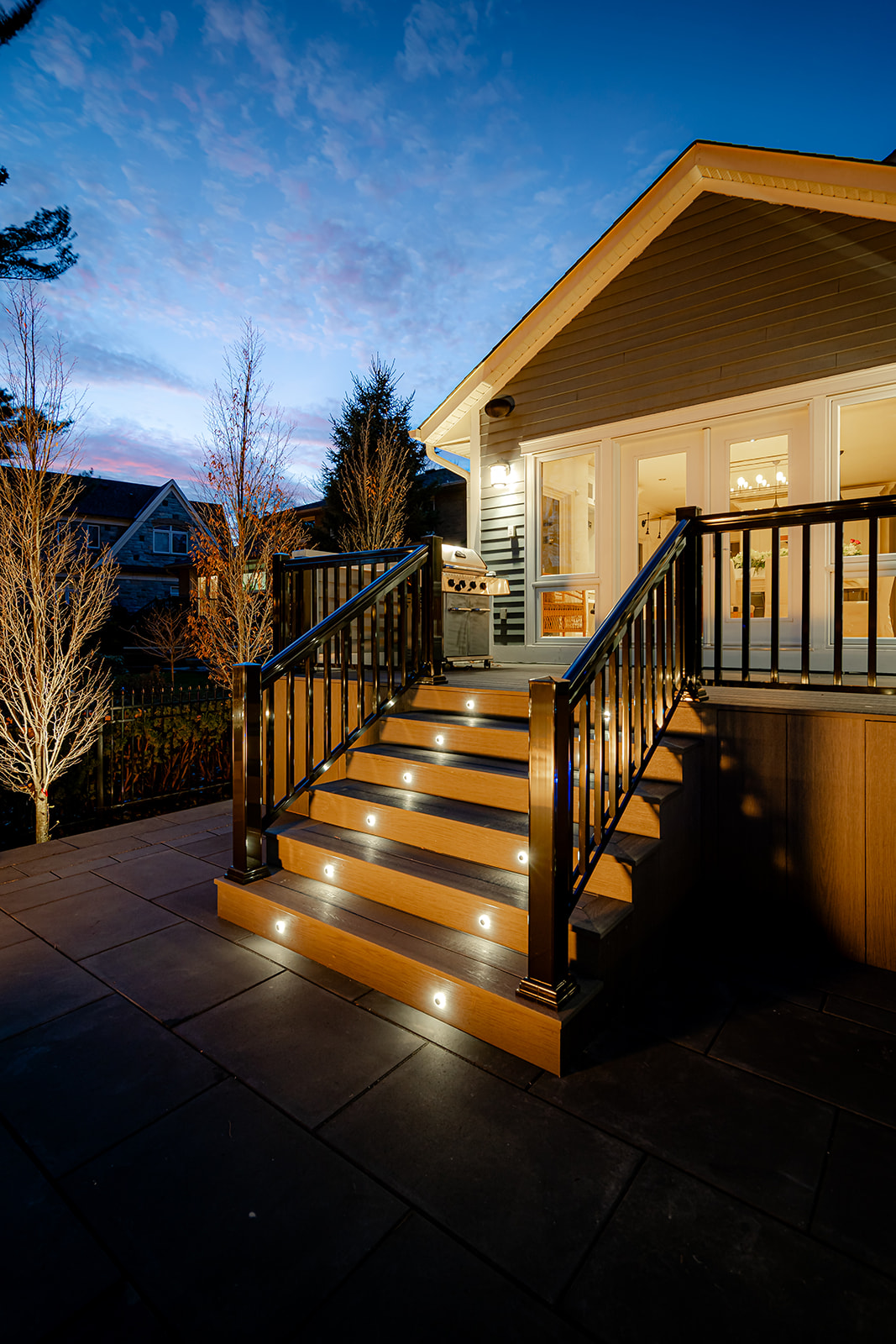 Stairs leading up toward the house with lights between the stairs.