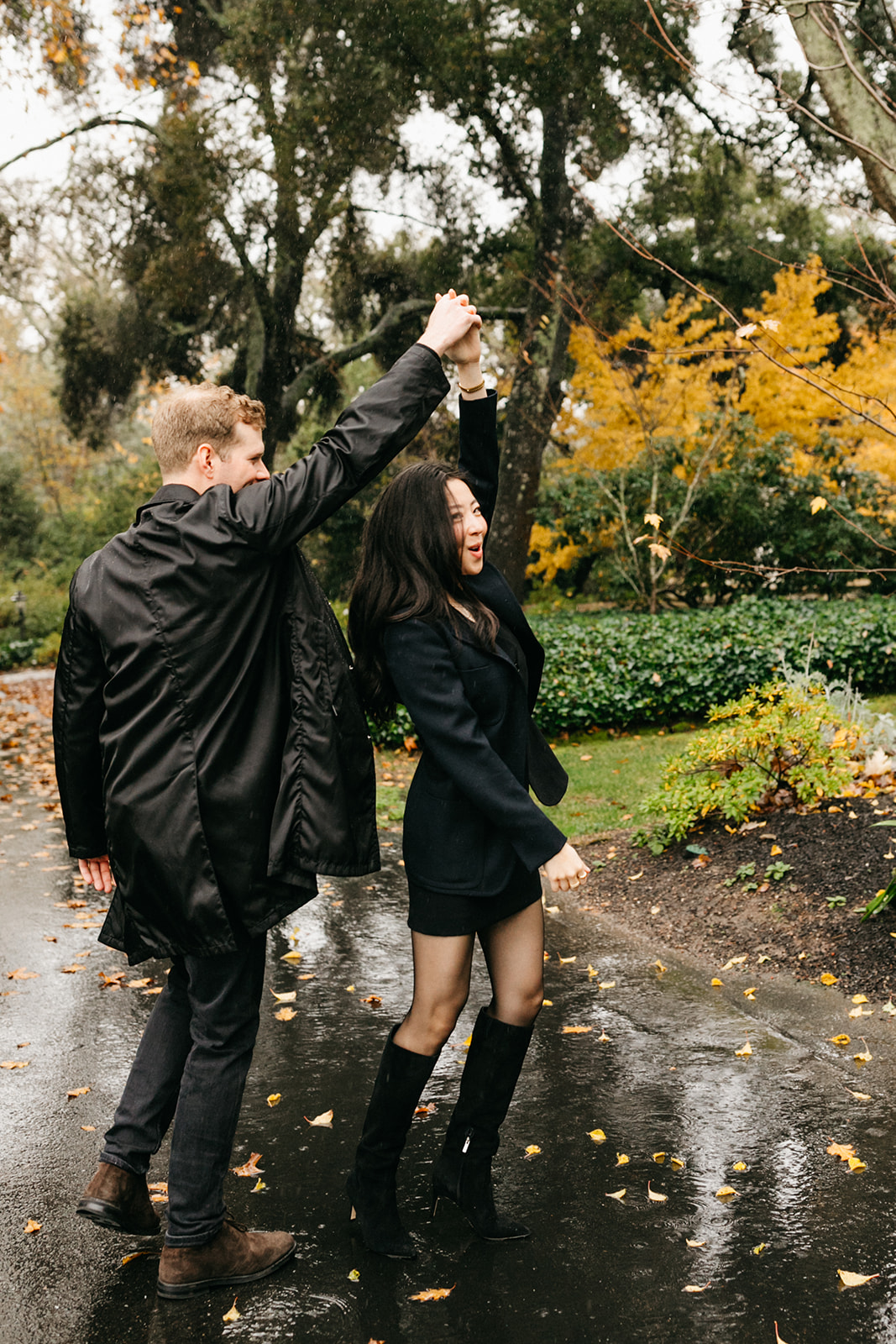 couple dancing in the rain during their proposal and engagement session
