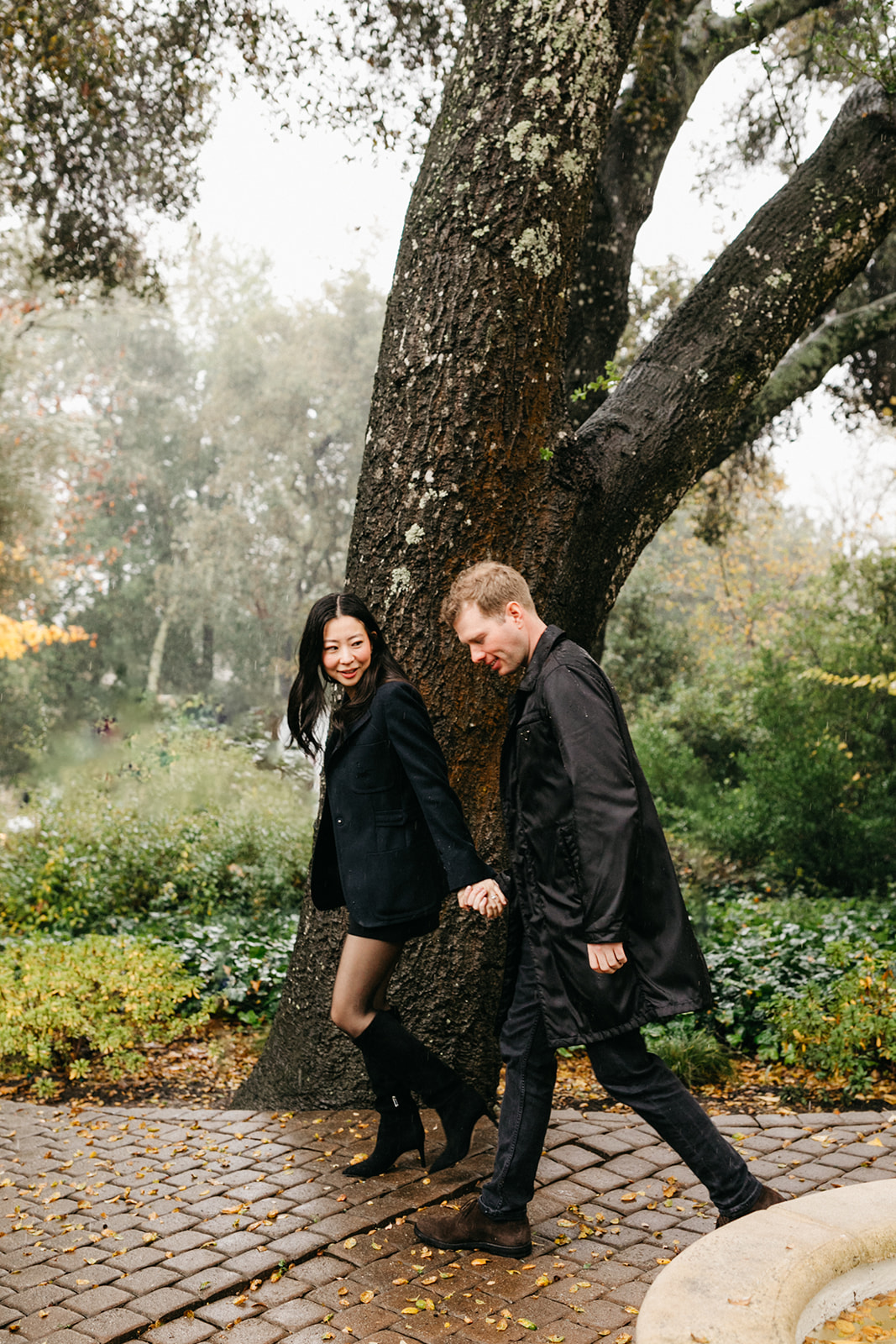 couple having fun in the rain at the madrona for their engagement session