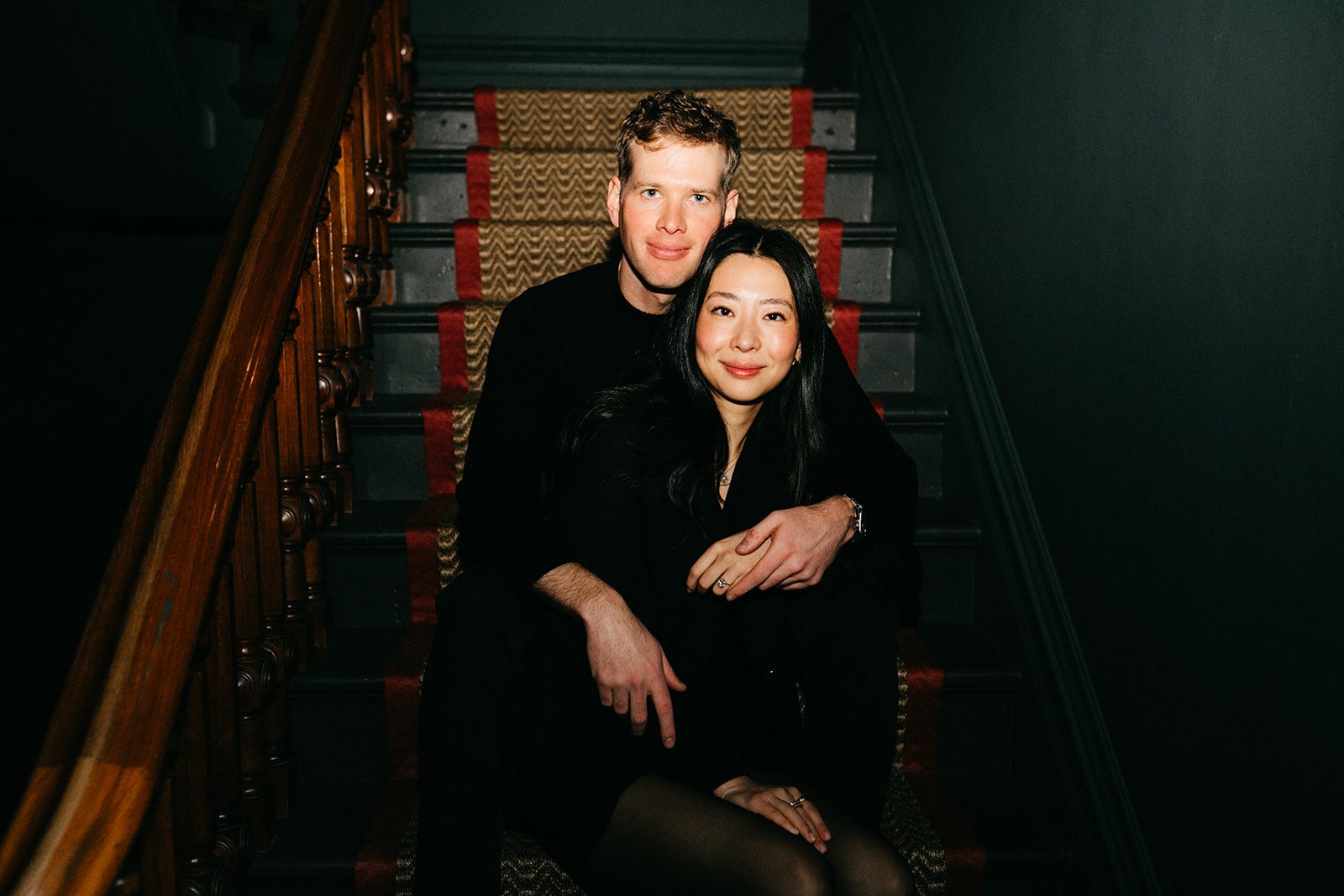 couple sitting on the stairs in the madrona for their engagement photos