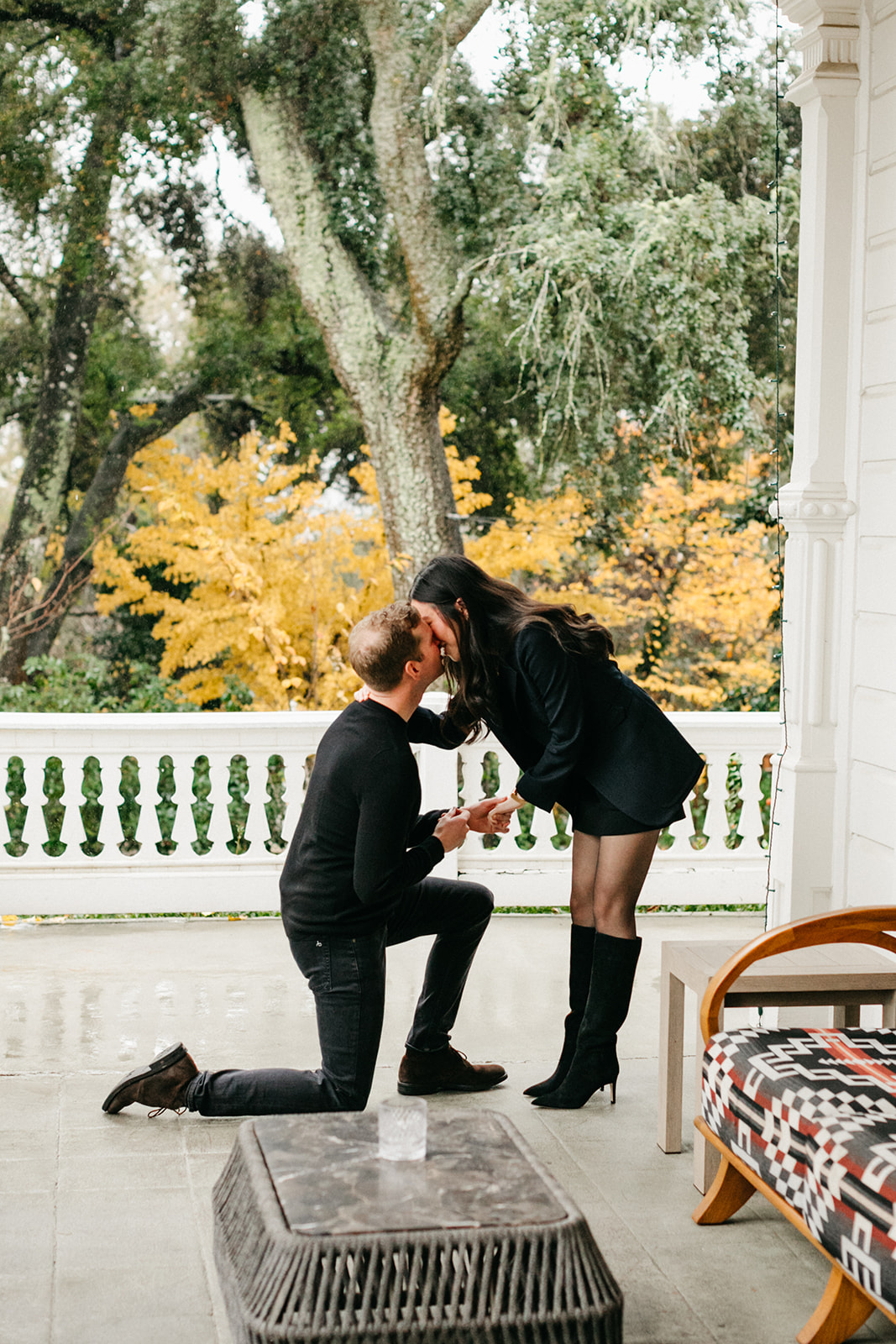 guy proposes to his girlfriend on the porch of the madrona