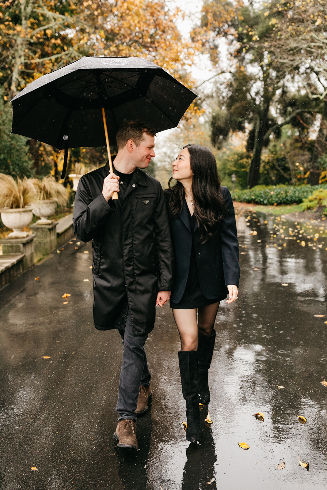 walking in rain together during engagement session