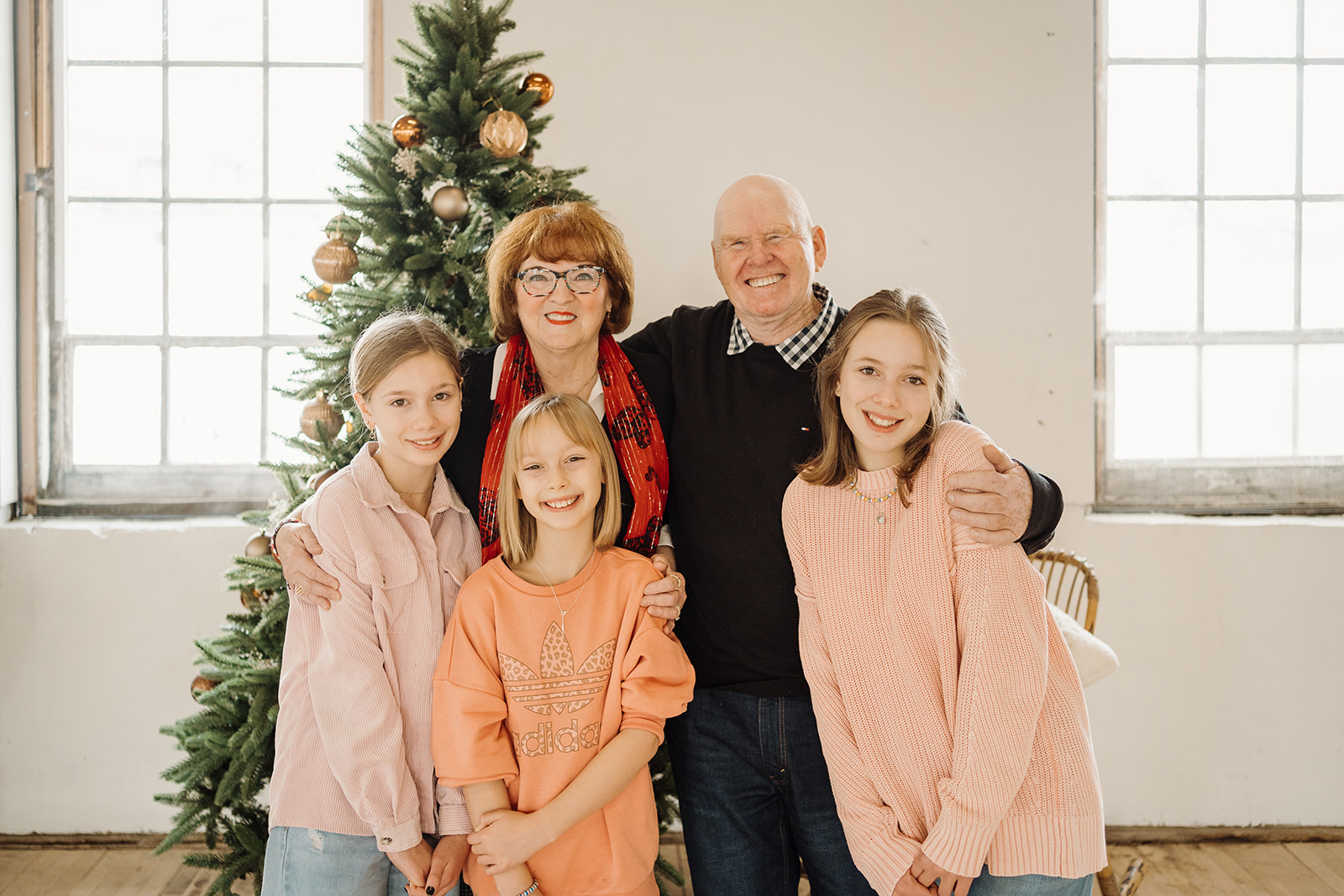 Five people standing in front of a Christmas Tree.
