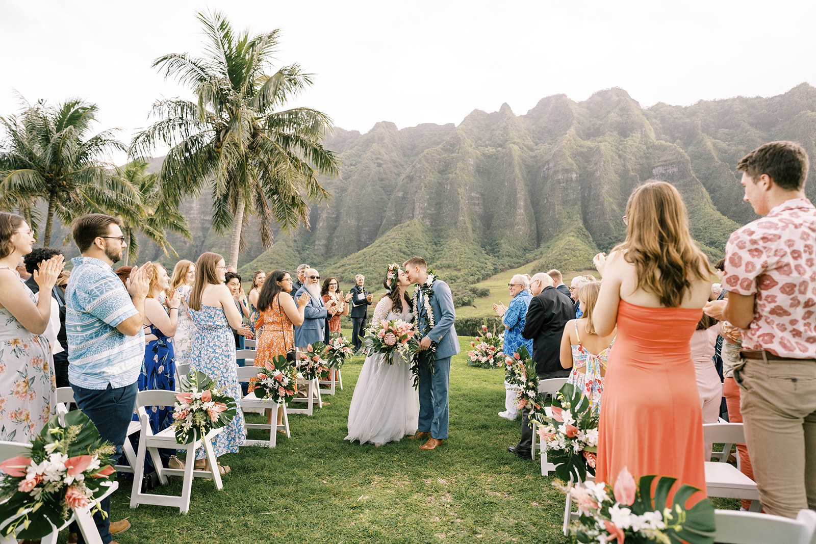 A bride and groom walk down the aisle at a hawaiian wedding.