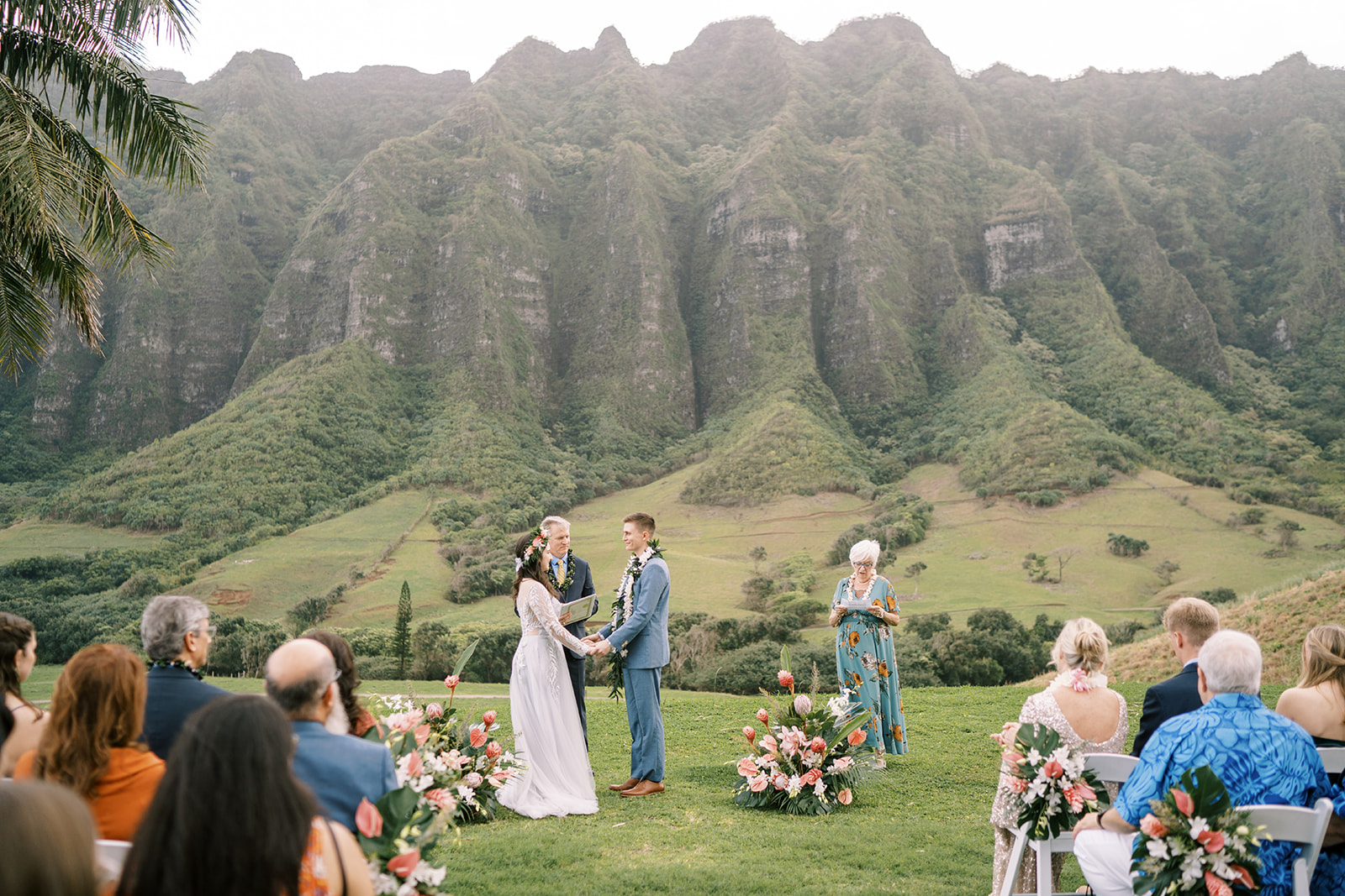 Hawaiian wedding ceremony on a field with the mountains in the background.