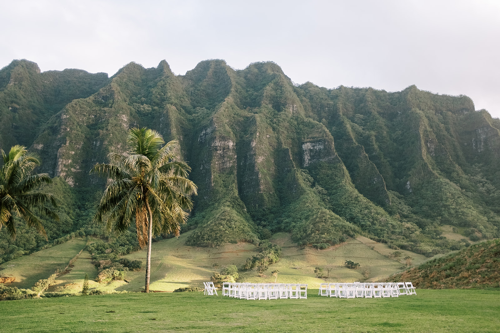 A destination wedding ceremony in front of a mountain at Kualoa Ranch, Hawaii.
