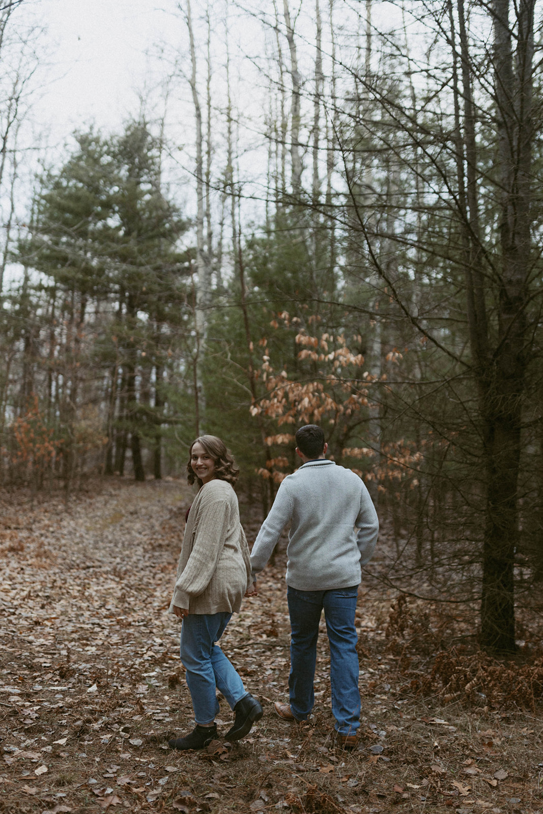 Couple walking through private woods in Mears, Michigan.