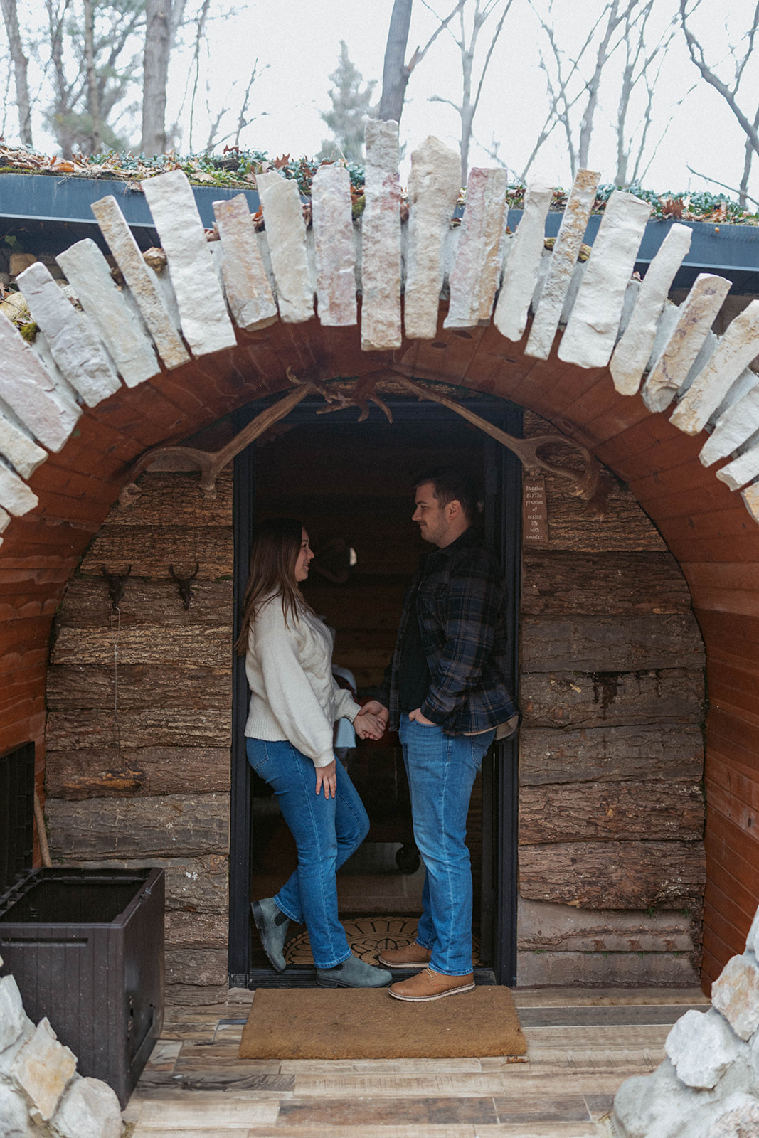 Couple holding hands outside hobbit hole during their unique engagement session