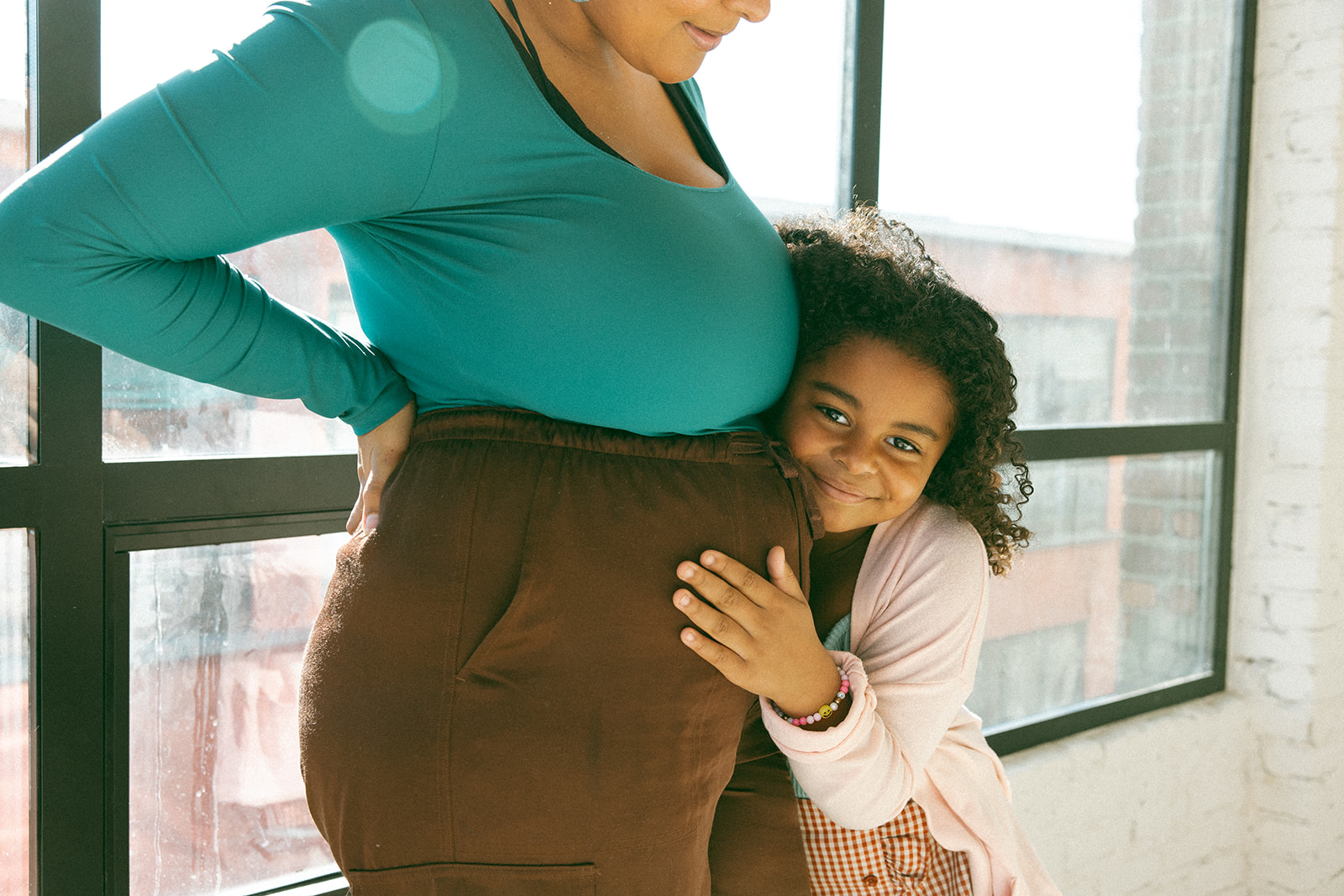 daughter hugging her mom's belly