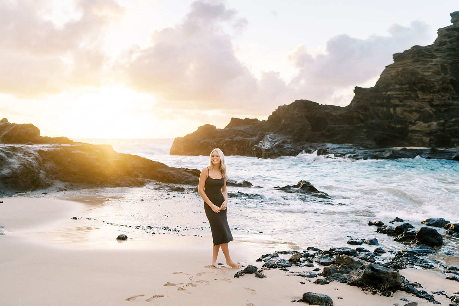 Woman smiling on a beach at high school senior portrait at Halona Cove in Oahu
