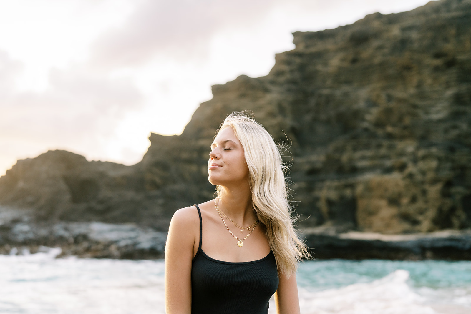 Woman enjoying a peaceful moment by the sea, high school senior portrait in Oahu
