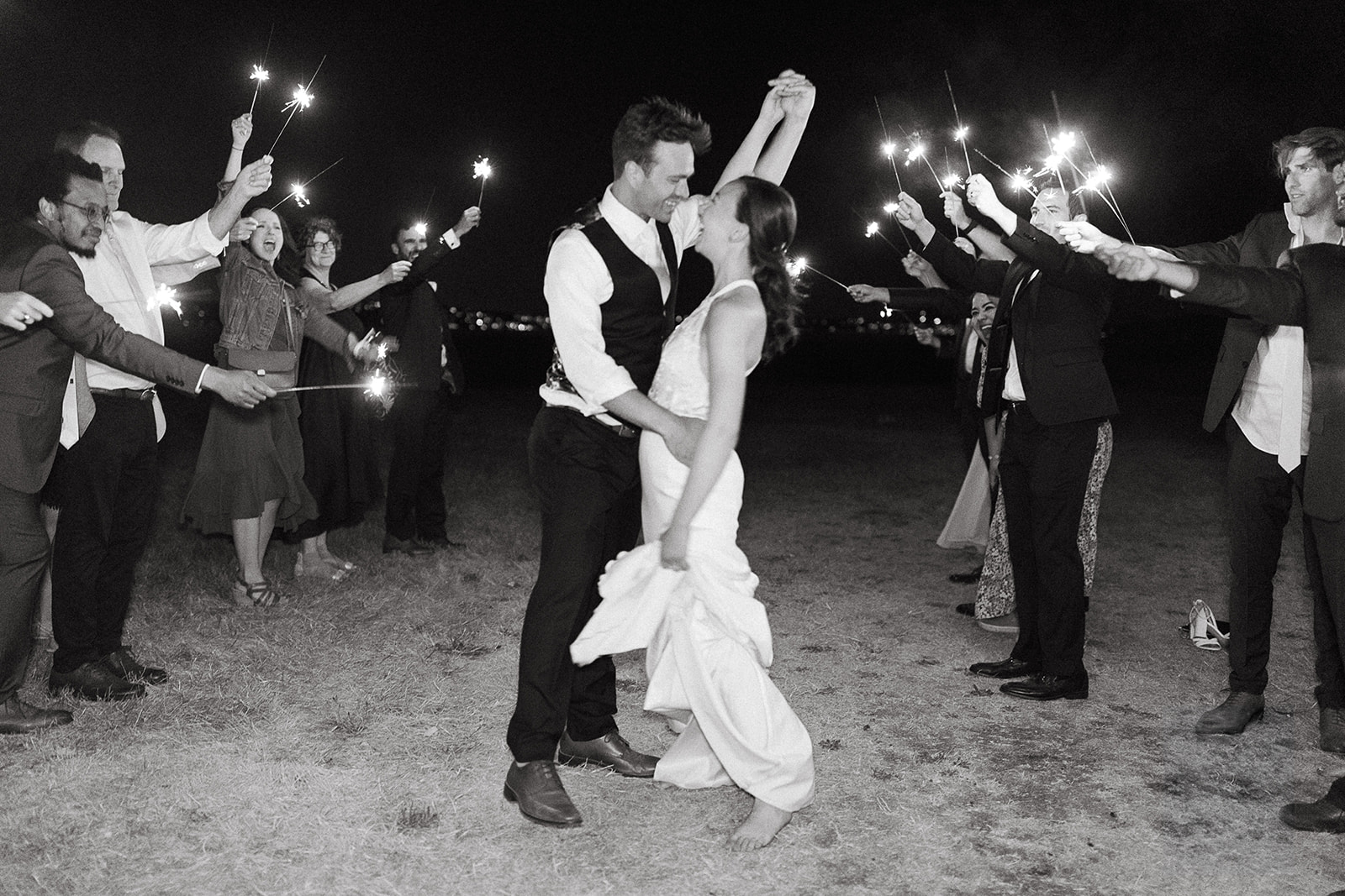 Bride and groom exiting their wedding with guest holding sparklers. 