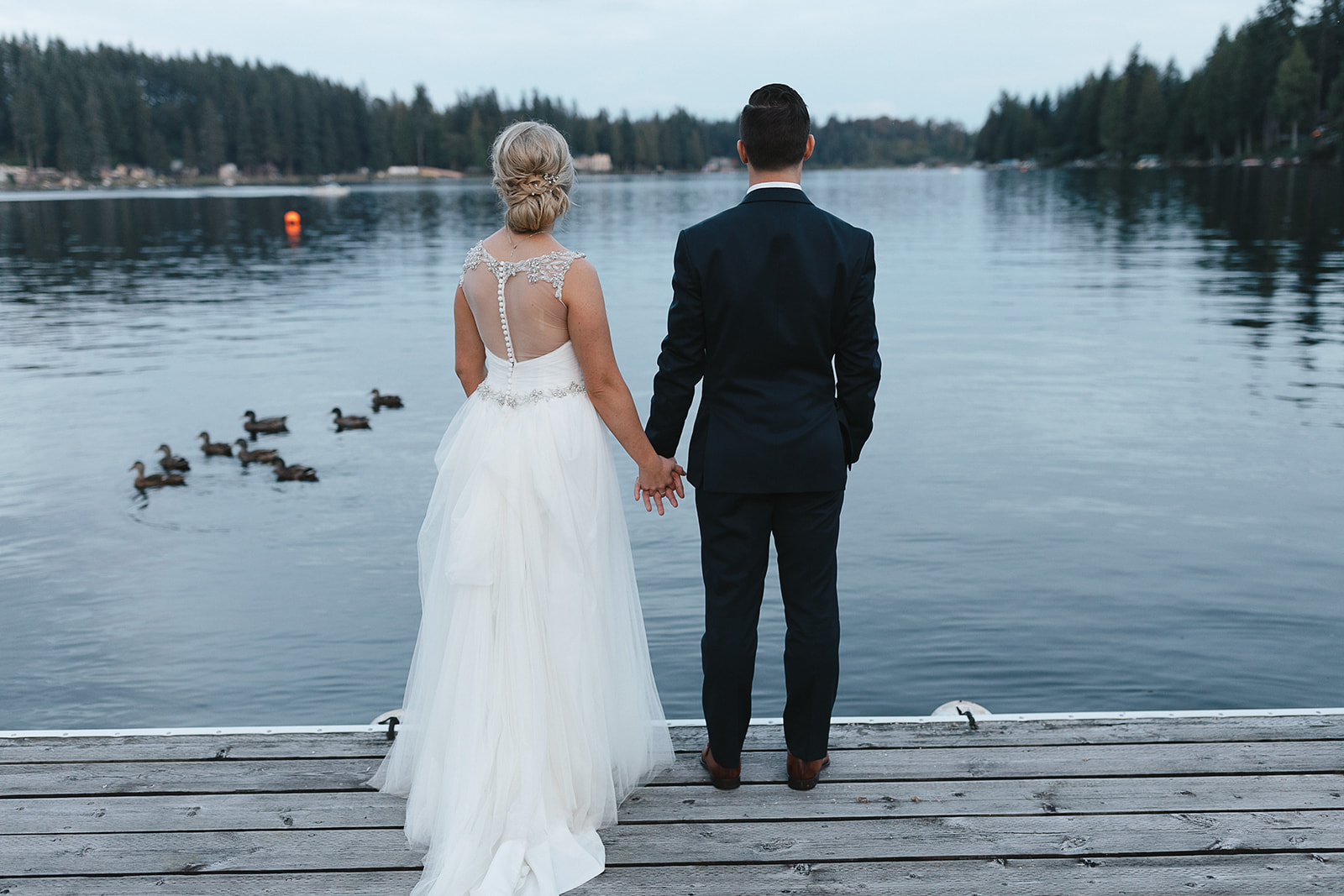 bride and groom enjoying a moment on a dock on Flowing Lake in Snohomish.