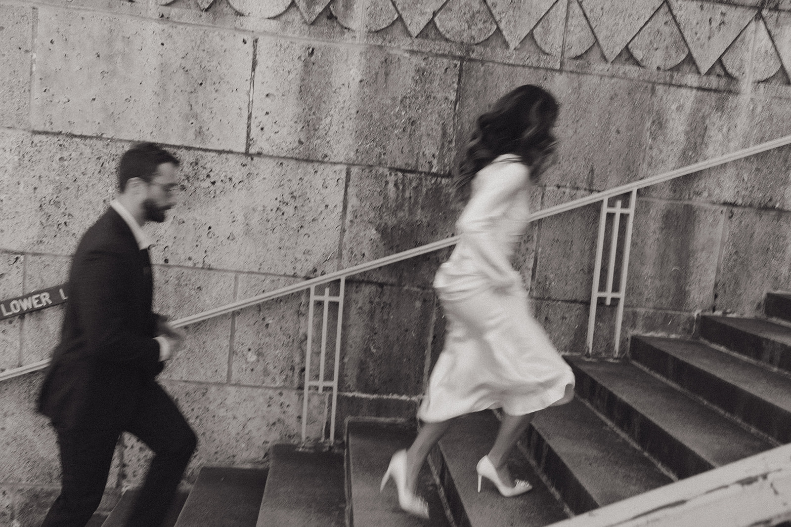 bride and groom running up the steps outside of the courthouse after their elopement in downtown Austin 