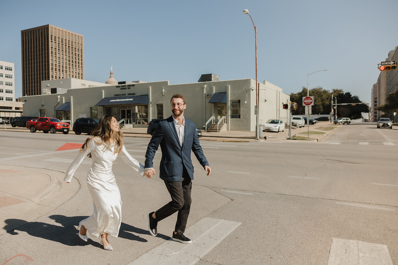 bride and groom leaving their elopement crossing the street outside